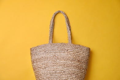 Stylish straw bag on yellow background, top view. Summer accessory Photo of Stylish straw bag on yellow background, top view. Summer accessory