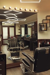 Stylish hairdresser's workplace with professional armchair in barbershop Photo of Stylish hairdresser's workplace with professional armchair in barbershop