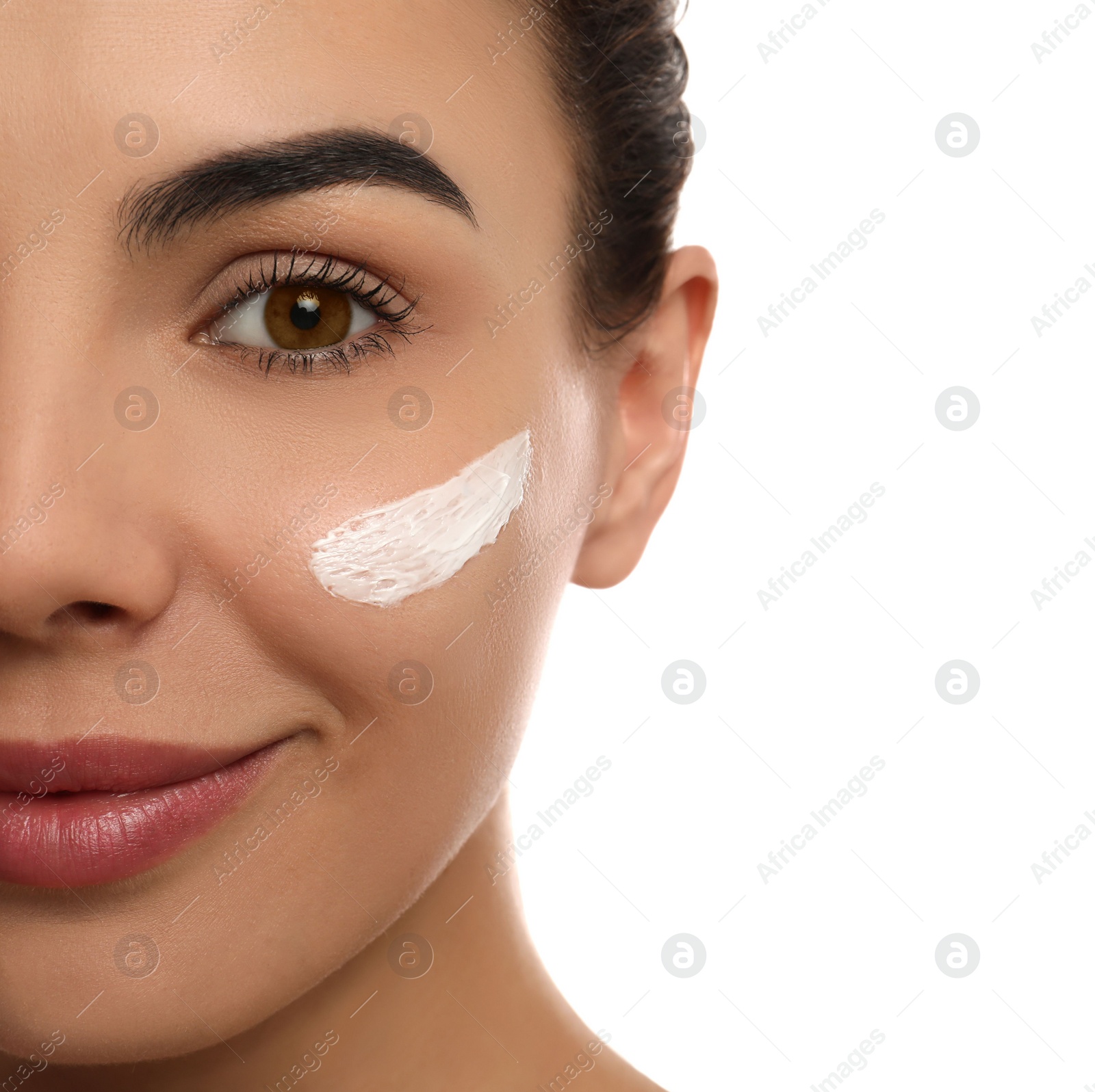 Young woman with cream on face against white background, closeup Photo of Young woman with cream on face against white background, closeup