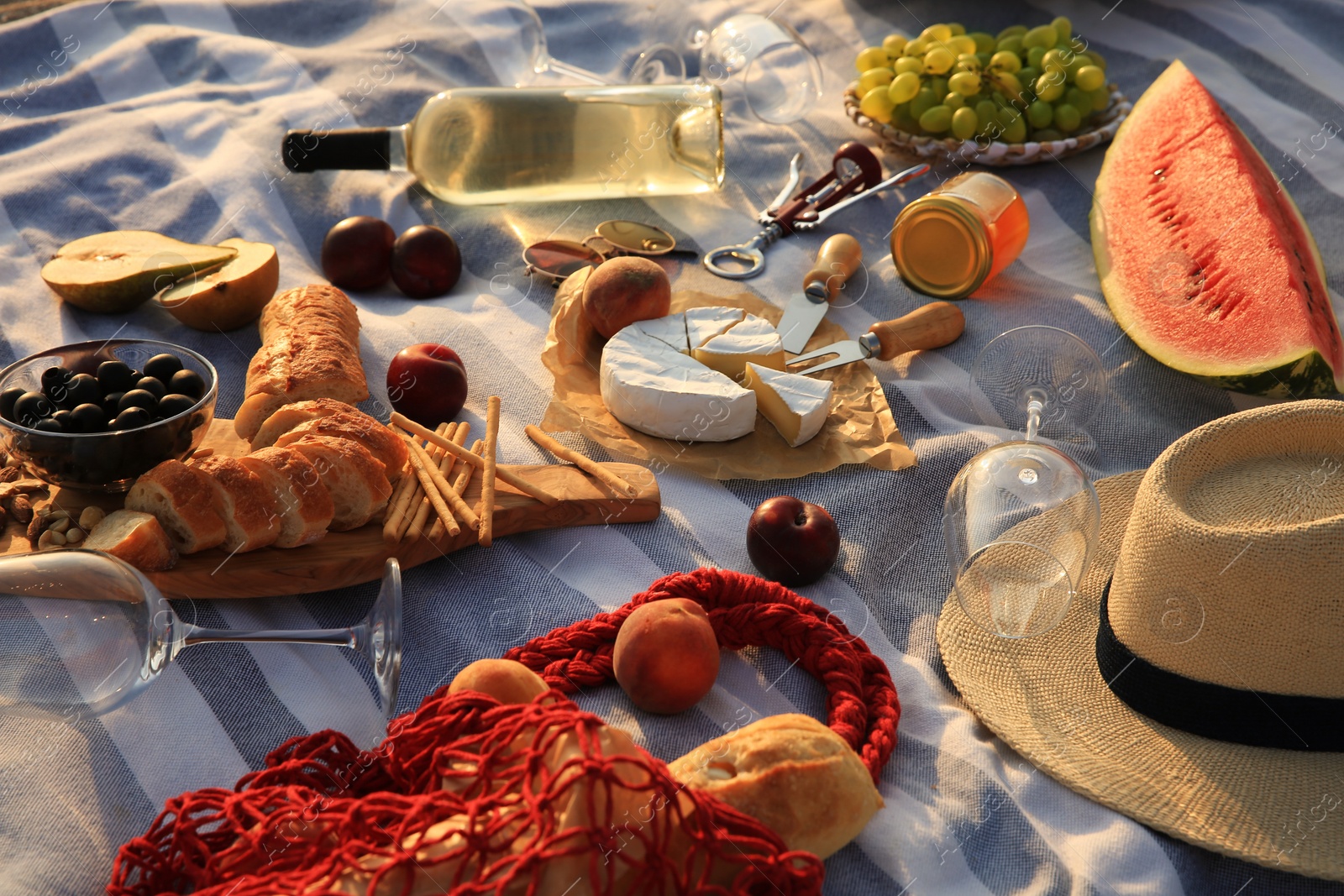 Many different tasty snacks and wine on picnic blanket Photo of Many different tasty snacks and wine on picnic blanket