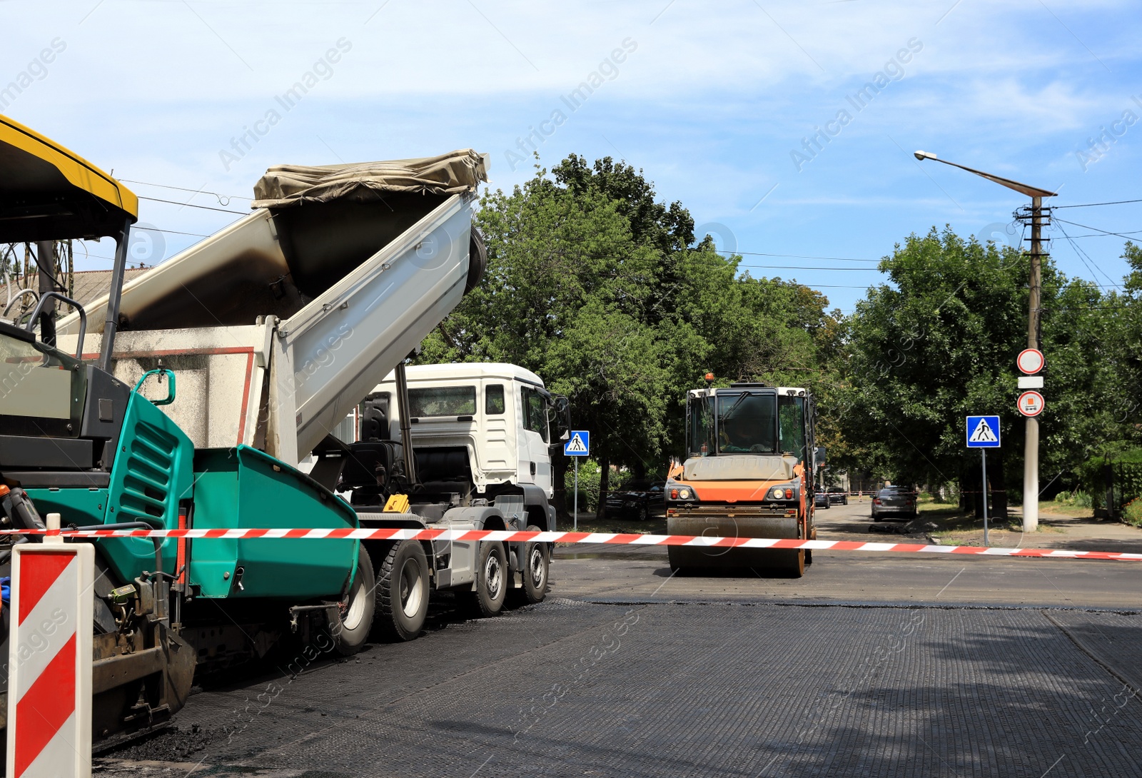 Road repair machinery working on city street Photo of Road repair machinery working on city street