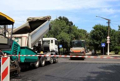 Road repair machinery working on city street Photo of Road repair machinery working on city street