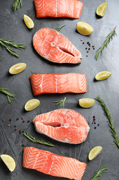 Flat lay composition with fresh raw salmon, rosemary and lemon on dark grey table. Fish delicacy Photo of Flat lay composition with fresh raw salmon, rosemary and lemon on dark grey table. Fish delicacy
