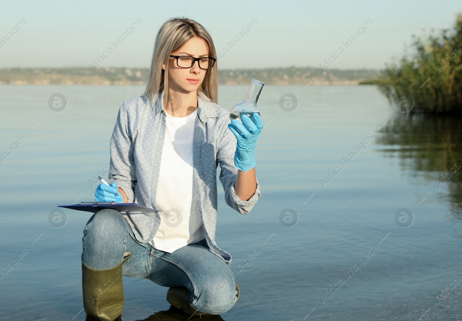 Scientist with clipboard and sample taken from river Photo of Scientist with clipboard and sample taken from river