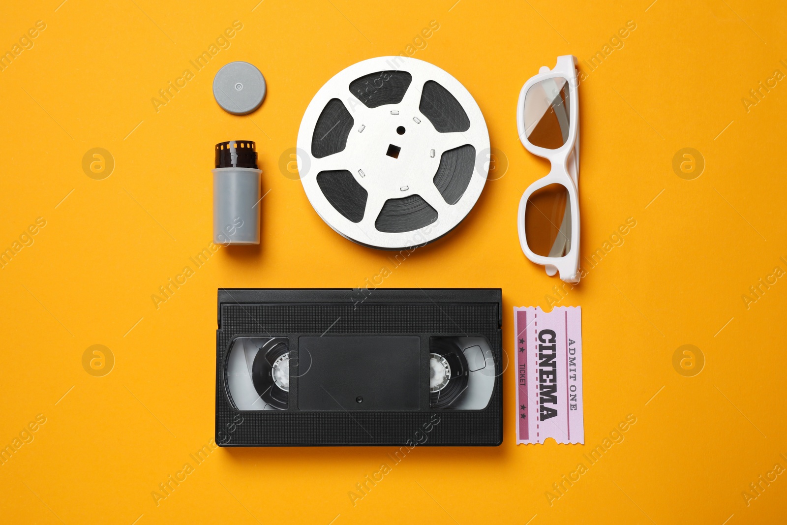 Flat lay composition with film reel and cinema ticket on orange background Photo of Flat lay composition with film reel and cinema ticket on orange background