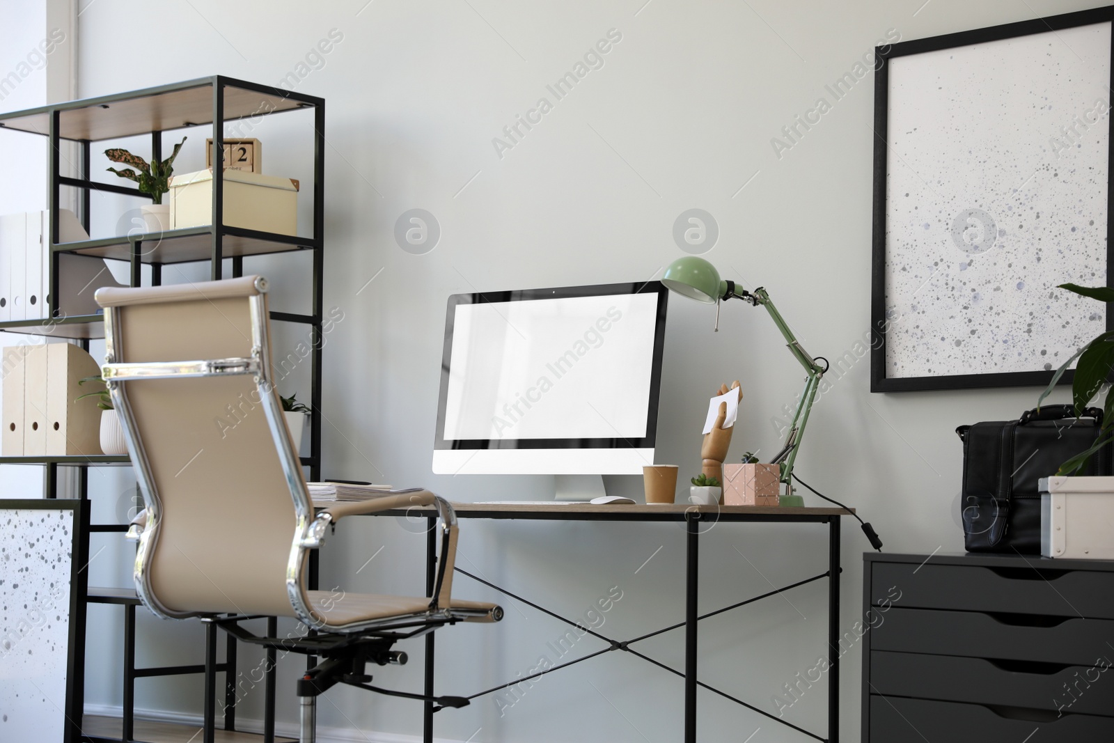 Comfortable office chair near desk with modern computer indoors Photo of Comfortable office chair near desk with modern computer indoors