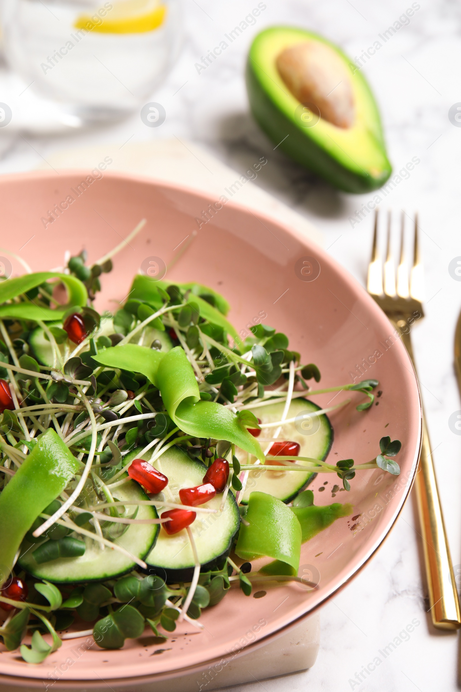 Salad with fresh organic microgreen in bowl on white table, closeup Photo of Salad with fresh organic microgreen in bowl on white table, closeup