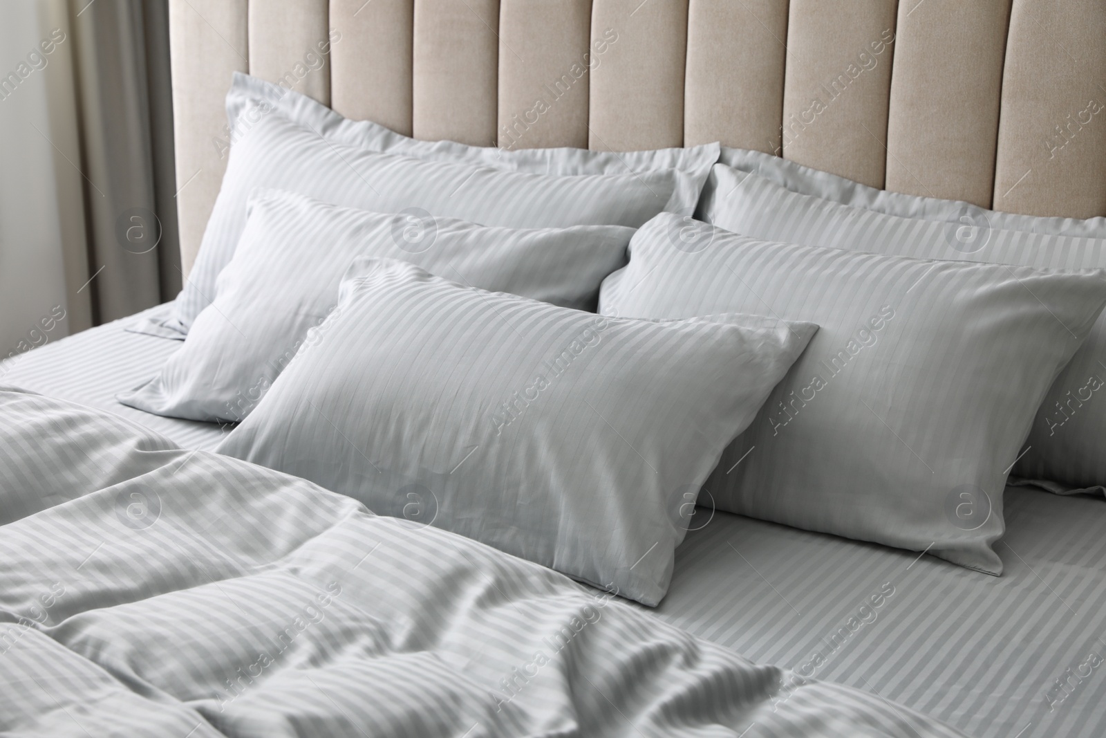 Comfortable bed with soft blanket and pillows indoors, closeup Photo of Comfortable bed with soft blanket and pillows indoors, closeup