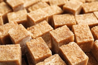 Cubes of brown sugar as background Photo of Cubes of brown sugar as background