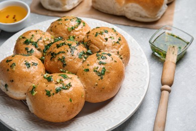 Traditional pampushka buns with garlic and herbs on grey table Photo of Traditional pampushka buns with garlic and herbs on grey table