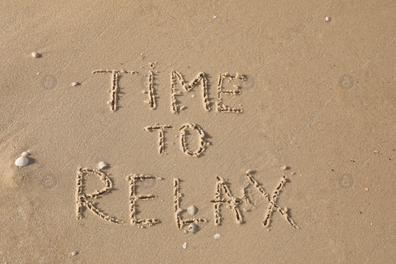 Phrase Time to Relax written on sand at beach, top view Photo of Phrase Time to Relax written on sand at beach, top view