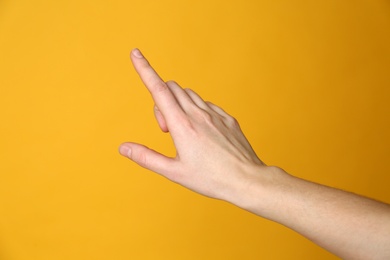 Woman pointing at something on yellow background, closeup. Finger gesture Photo of Woman pointing at something on yellow background, closeup. Finger gesture