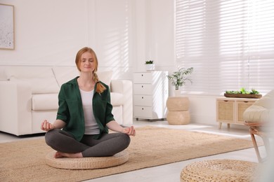 Woman meditating on wicker mat at home. Space for text Photo of Woman meditating on wicker mat at home. Space for text