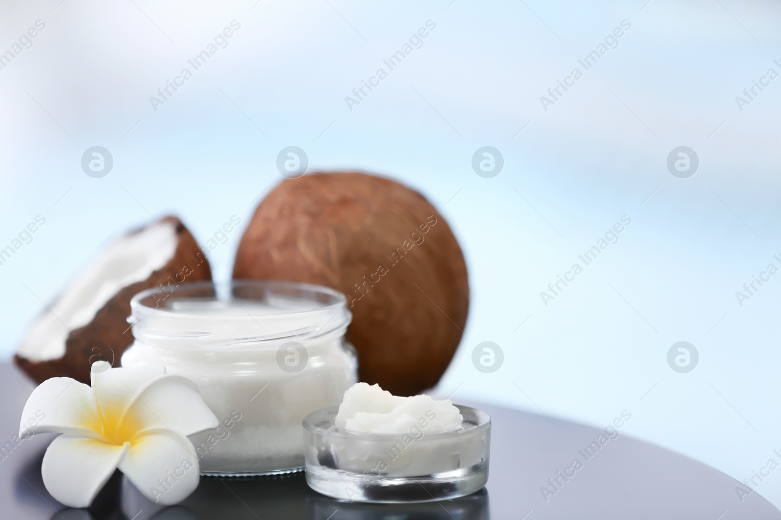 Composition with coconut butter in glass jar on blurred background Photo of Composition with coconut butter in glass jar on blurred background