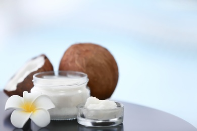 Composition with coconut butter in glass jar on blurred background Photo of Composition with coconut butter in glass jar on blurred background