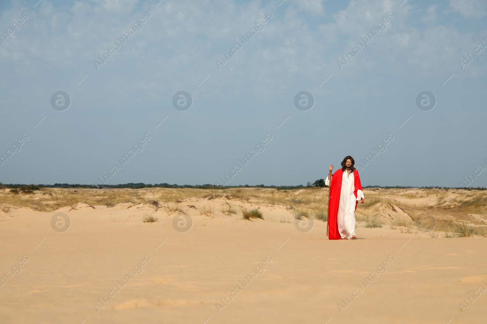 Jesus Christ walking with stick in desert. Space for text Photo of Jesus Christ walking with stick in desert. Space for text
