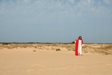 Jesus Christ walking with stick in desert. Space for text Photo of Jesus Christ walking with stick in desert. Space for text