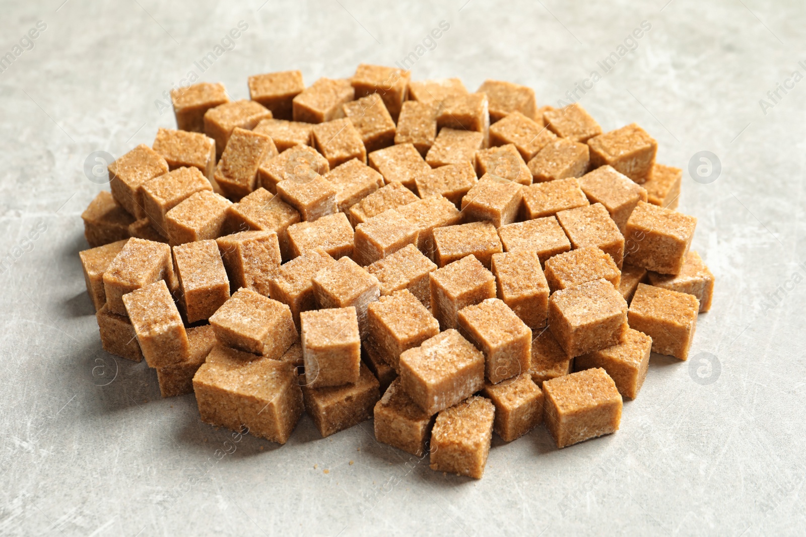 Cubes of brown sugar on gray table Photo of Cubes of brown sugar on gray table