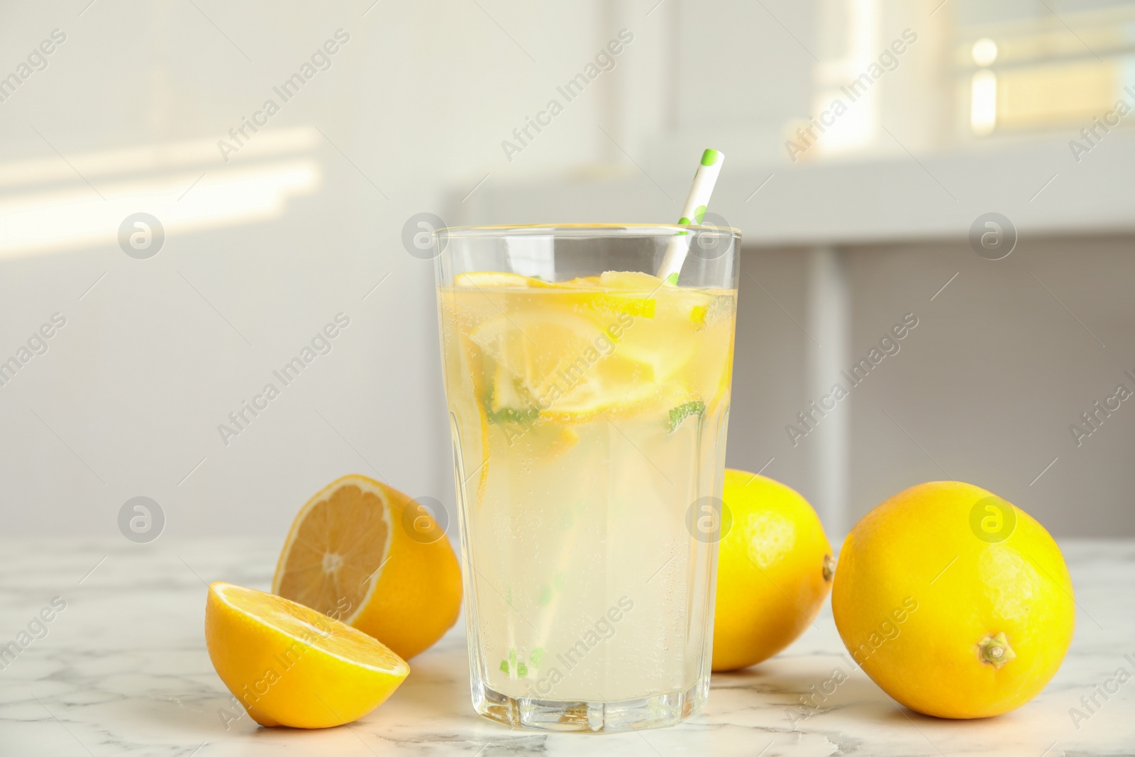 Photo of Cool freshly made lemonade and fruits on white marble table