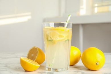 Cool freshly made lemonade and fruits on white marble table Photo of Cool freshly made lemonade and fruits on white marble table