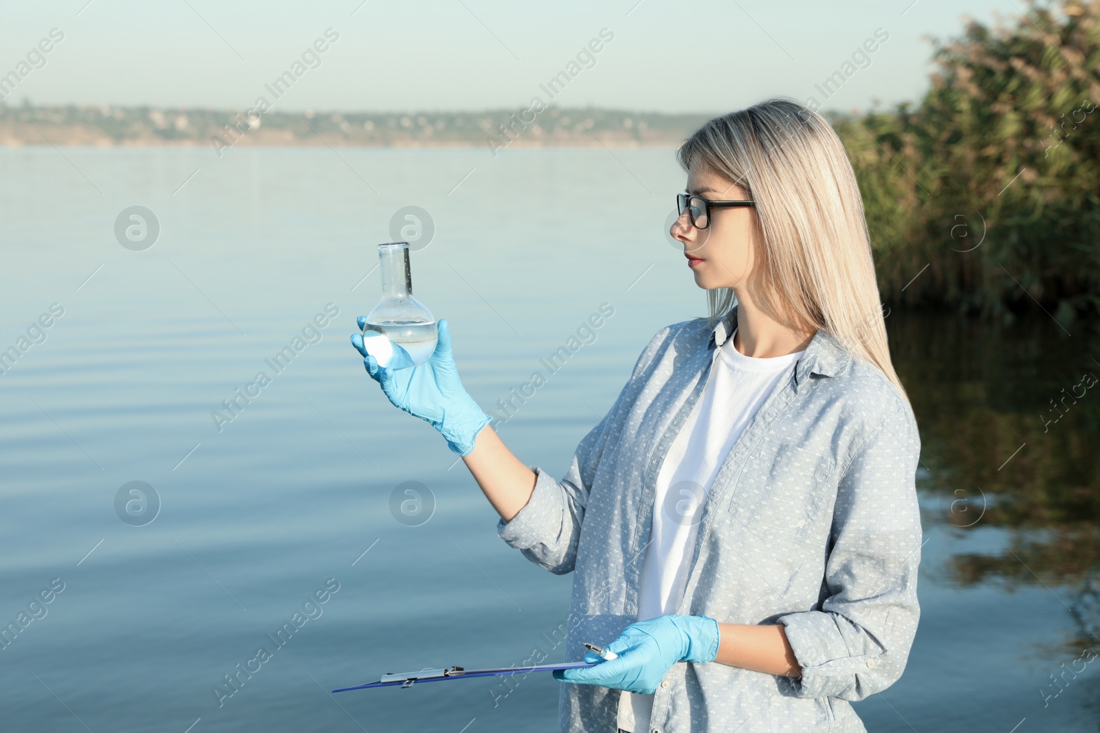 Scientist with clipboard and sample taken from river Photo of Scientist with clipboard and sample taken from river