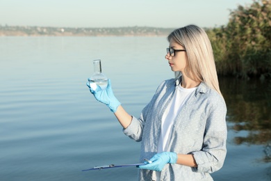 Scientist with clipboard and sample taken from river Photo of Scientist with clipboard and sample taken from river