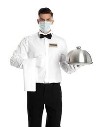 Waiter in medical face mask holding tray with lid on white background Photo of Waiter in medical face mask holding tray with lid on white background
