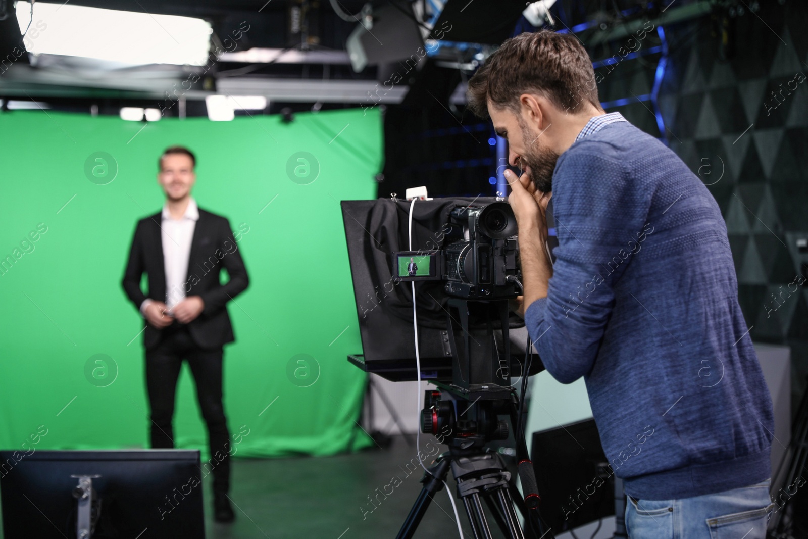 Photo of Presenter and video camera operator working in studio. News broadcasting