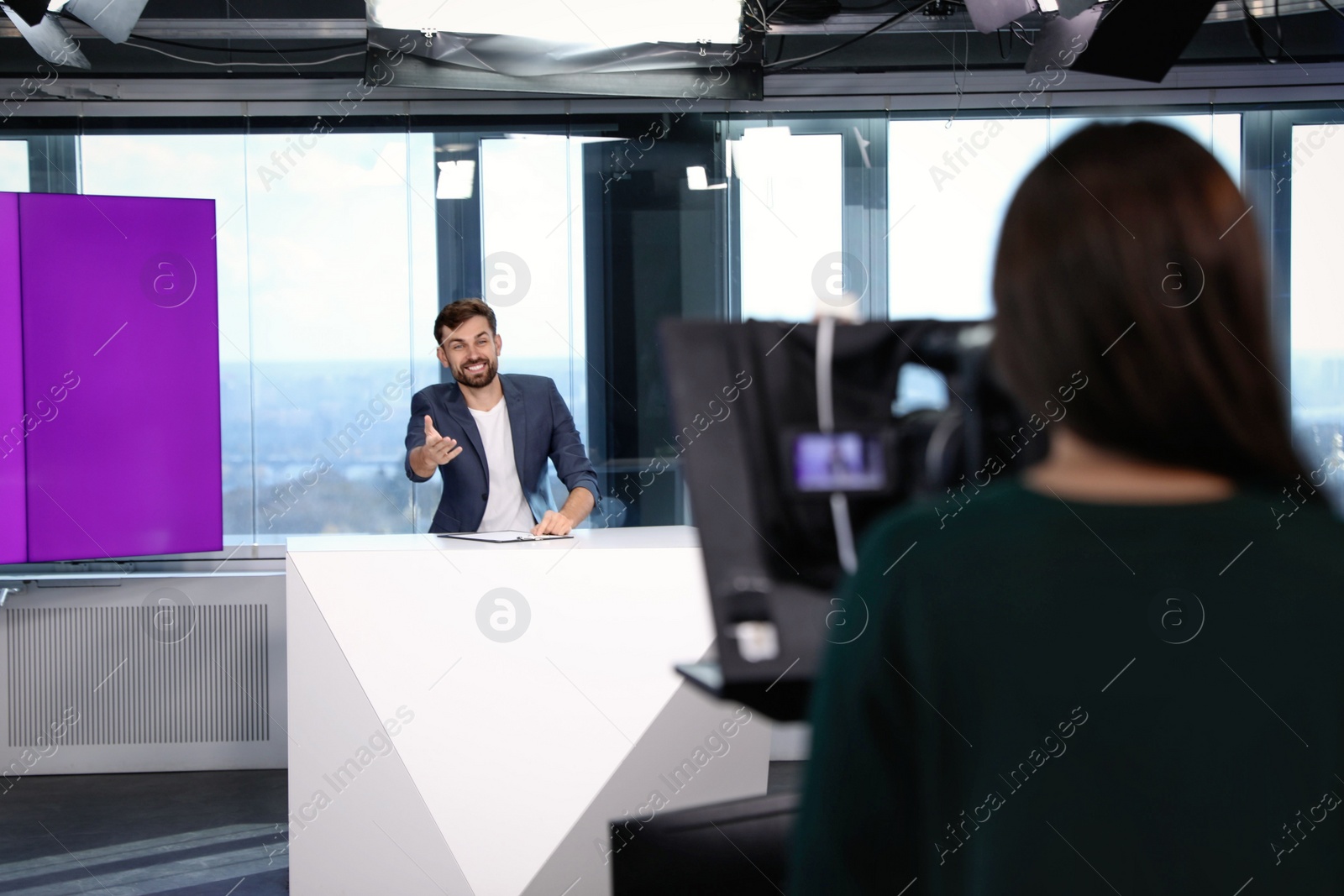 Presenter and video camera operator working in studio. News broadcasting Photo of Presenter and video camera operator working in studio. News broadcasting