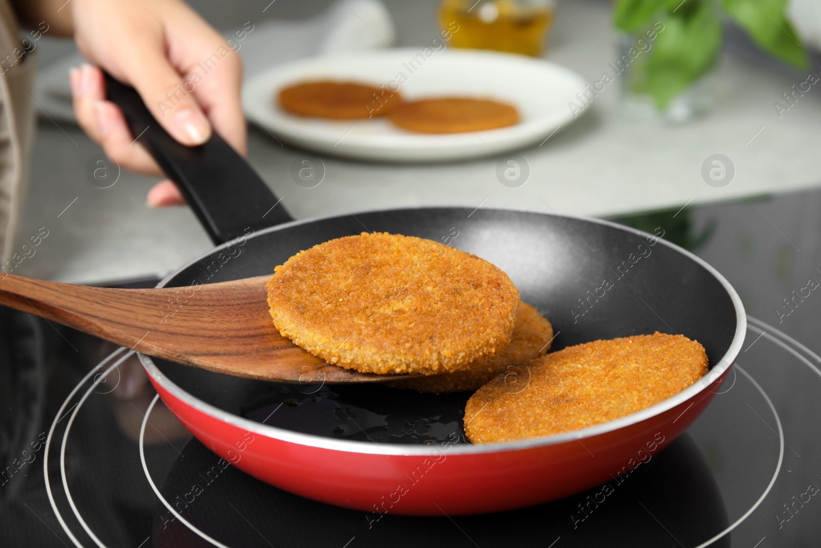 Woman cooking breaded cutlets in frying pan on stove, closeup Photo of Woman cooking breaded cutlets in frying pan on stove, closeup