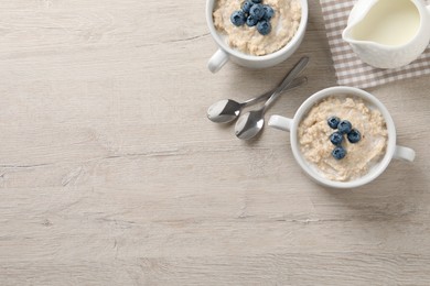 Tasty oatmeal porridge with blueberries served on light wooden table, flat lay. Space for text Photo of Tasty oatmeal porridge with blueberries served on light wooden table, flat lay. Space for text