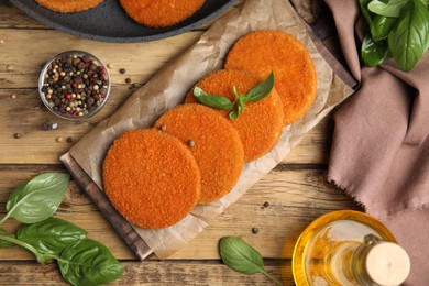 Delicious fried breaded cutlets served on wooden table, flat lay Photo of Delicious fried breaded cutlets served on wooden table, flat lay