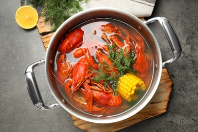 Fresh delicious crayfishes in pot on grey table, flat lay Photo of Fresh delicious crayfishes in pot on grey table, flat lay