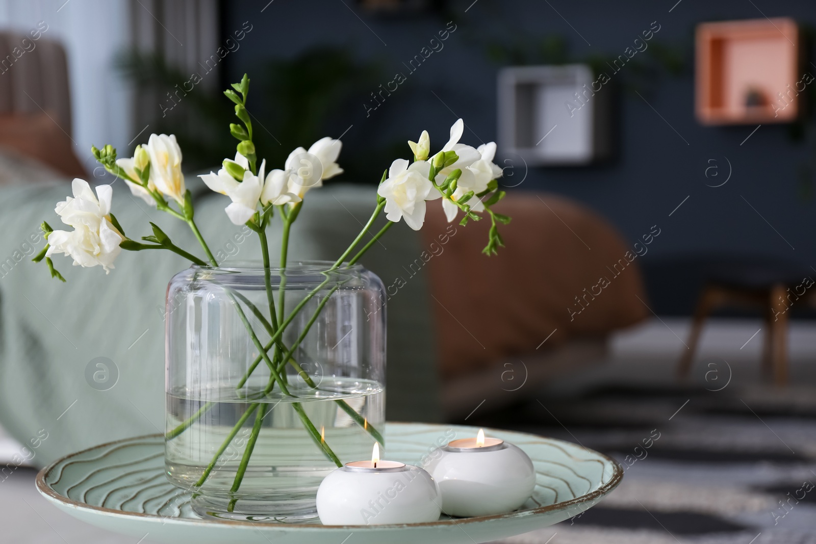 Vase with beautiful freesia flowers and burning candles on stand in bedroom, space for text. Interior elements Photo of Vase with beautiful freesia flowers and burning candles on stand in bedroom, space for text. Interior elements