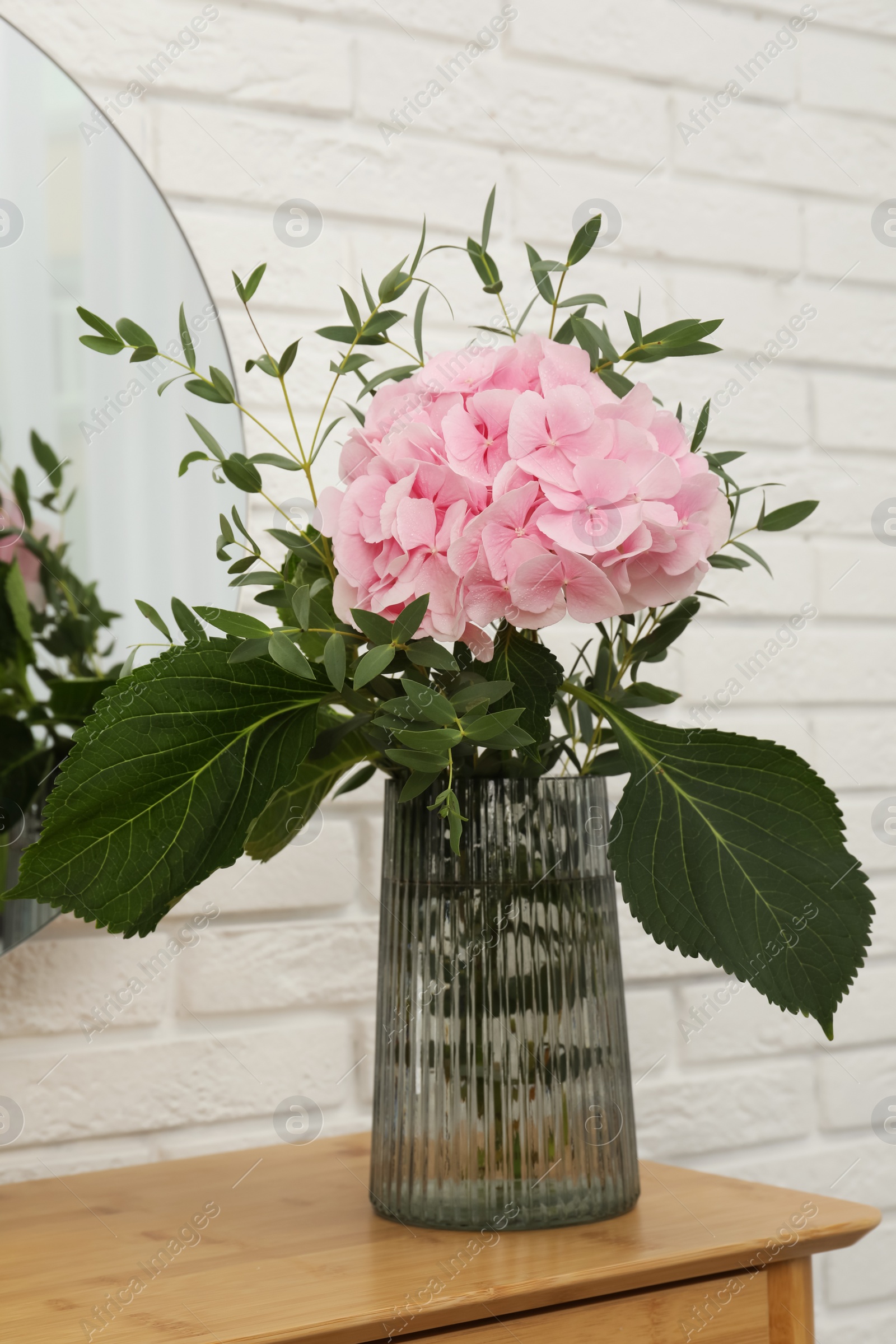 Beautiful pink hortensia flowers in vase on dressing table indoors Photo of Beautiful pink hortensia flowers in vase on dressing table indoors