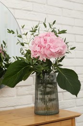 Beautiful pink hortensia flowers in vase on dressing table indoors Photo of Beautiful pink hortensia flowers in vase on dressing table indoors