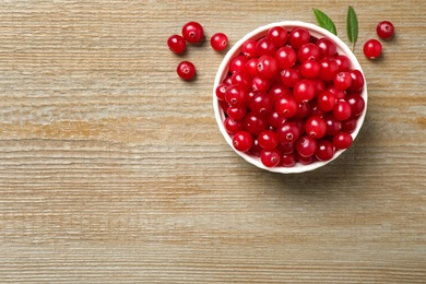 Tasty ripe cranberries on wooden table, flat lay. Space for text Photo of Tasty ripe cranberries on wooden table, flat lay. Space for text