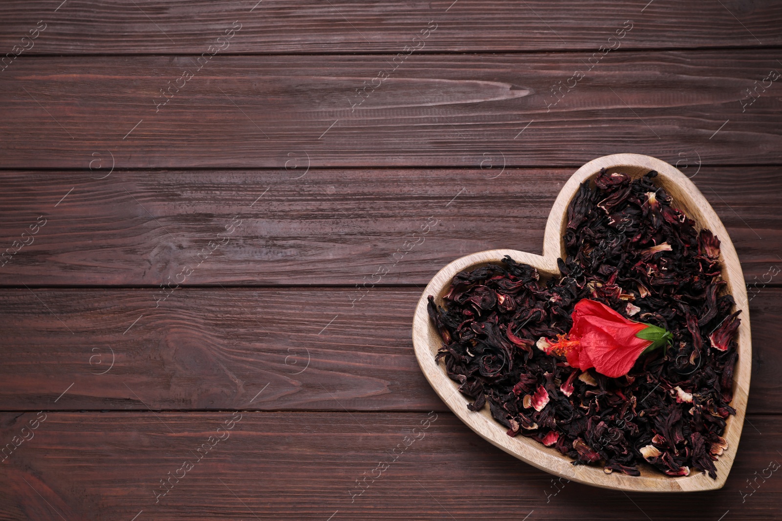 Dry hibiscus tea and flower on wooden table, top view. Space for text Photo of Dry hibiscus tea and flower on wooden table, top view. Space for text