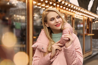 Young woman near cafe decorated for Christmas Photo of Young woman near cafe decorated for Christmas