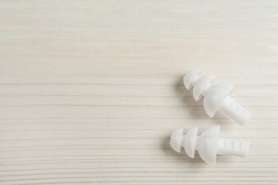 Pair of ear plugs on white wooden background, flat lay. Space for text Photo of Pair of ear plugs on white wooden background, flat lay. Space for text