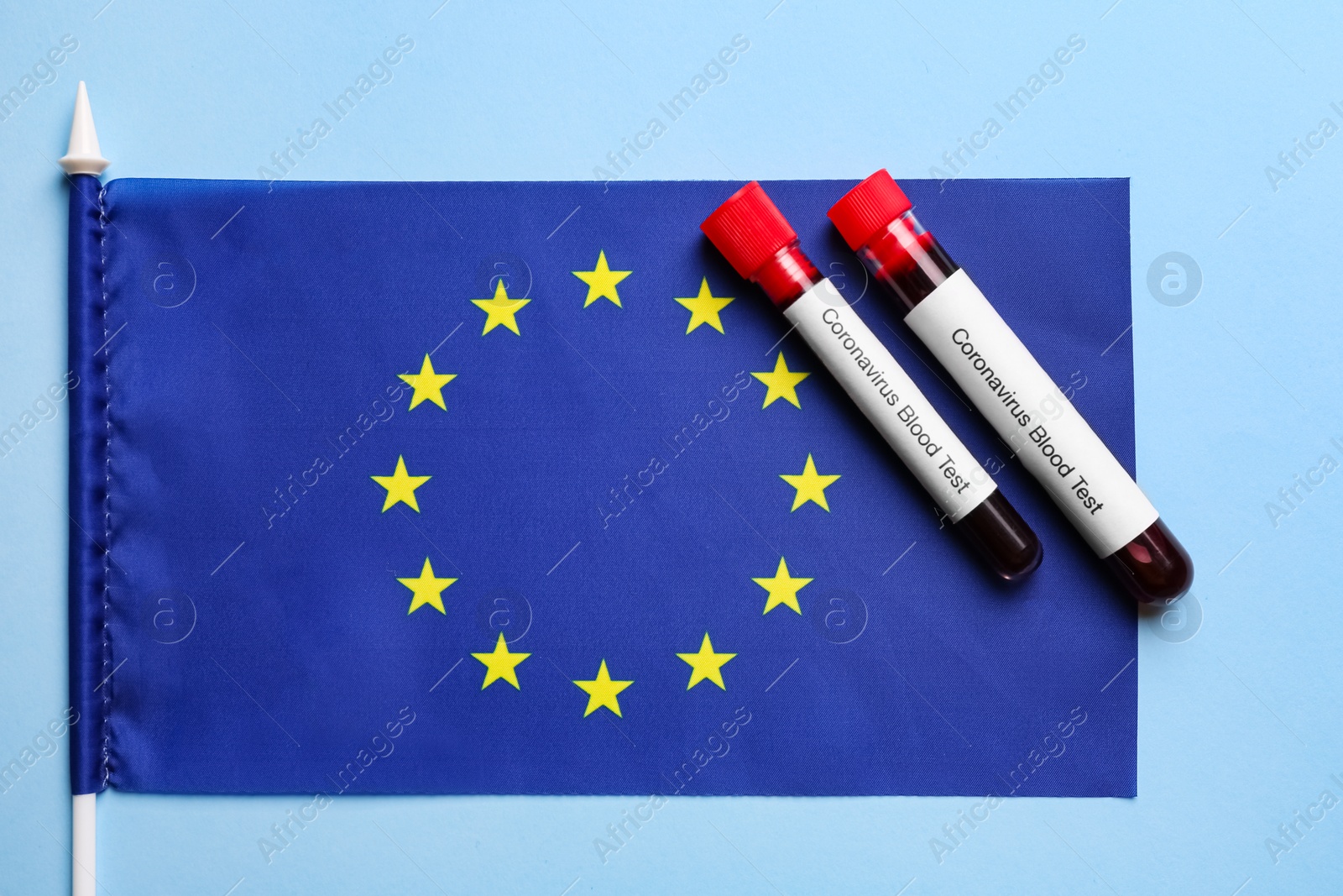 Test tubes with blood samples and European Union flag on light blue background, flat lay. Coronavirus outbreak Photo of Test tubes with blood samples and European Union flag on light blue background, flat lay. Coronavirus outbreak