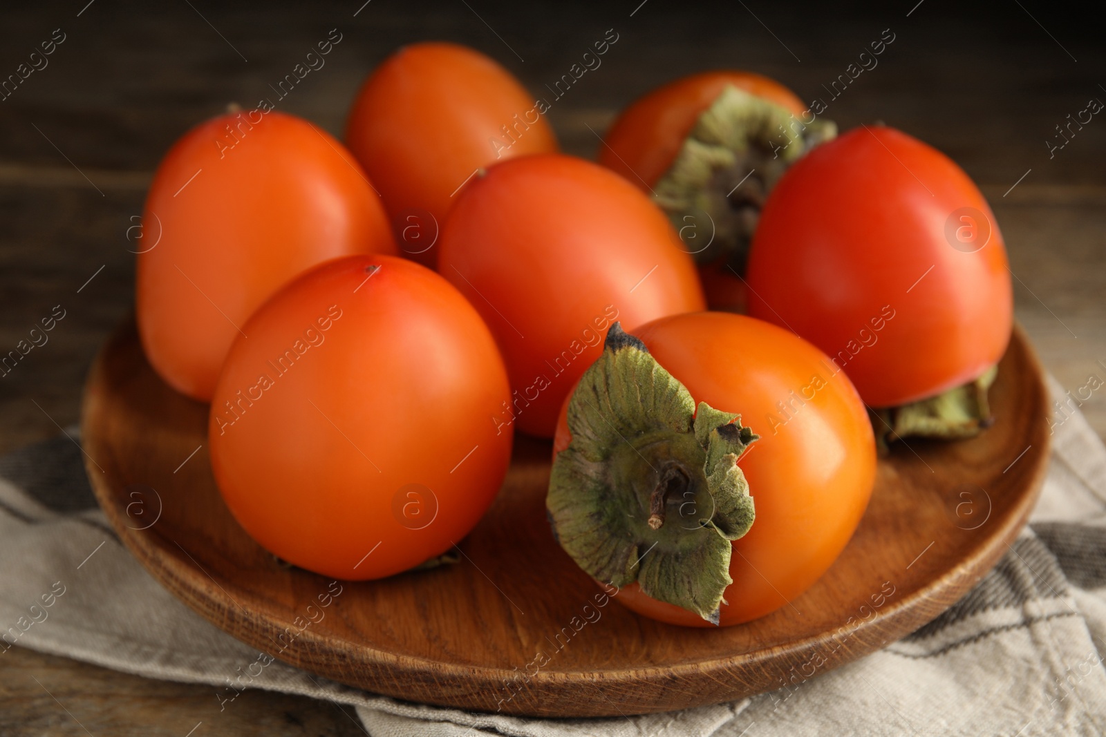 Tasty ripe persimmons on wooden table, closeup Photo of Tasty ripe persimmons on wooden table, closeup