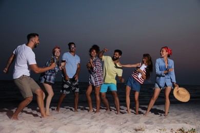Happy friends enjoying summer beach party in evening Photo of Happy friends enjoying summer beach party in evening