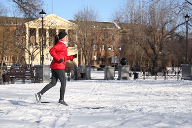 Happy woman running along park on winter day. Outdoors sports exercises Photo of Happy woman running along park on winter day. Outdoors sports exercises