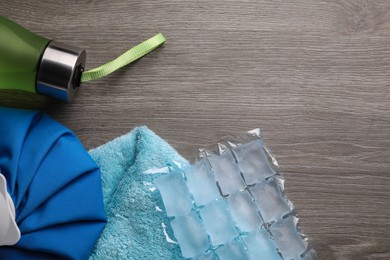Bottle of water, ice pack, cold compress and towel on wooden background, flat lay with space for text. Heat stroke treatment Photo of Bottle of water, ice pack, cold compress and towel on wooden background, flat lay with space for text. Heat stroke treatment