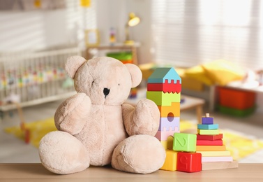 Set of different cute toys on wooden table in children's room Image of Set of different cute toys on wooden table in children's room