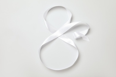 Number 8 made of white ribbon on light grey background, top view. International Women's day Photo of Number 8 made of white ribbon on light grey background, top view. International Women's day