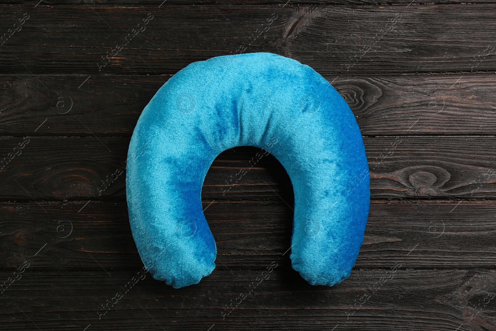 Blue travel pillow on wooden background, top view Image of Blue travel pillow on wooden background, top view