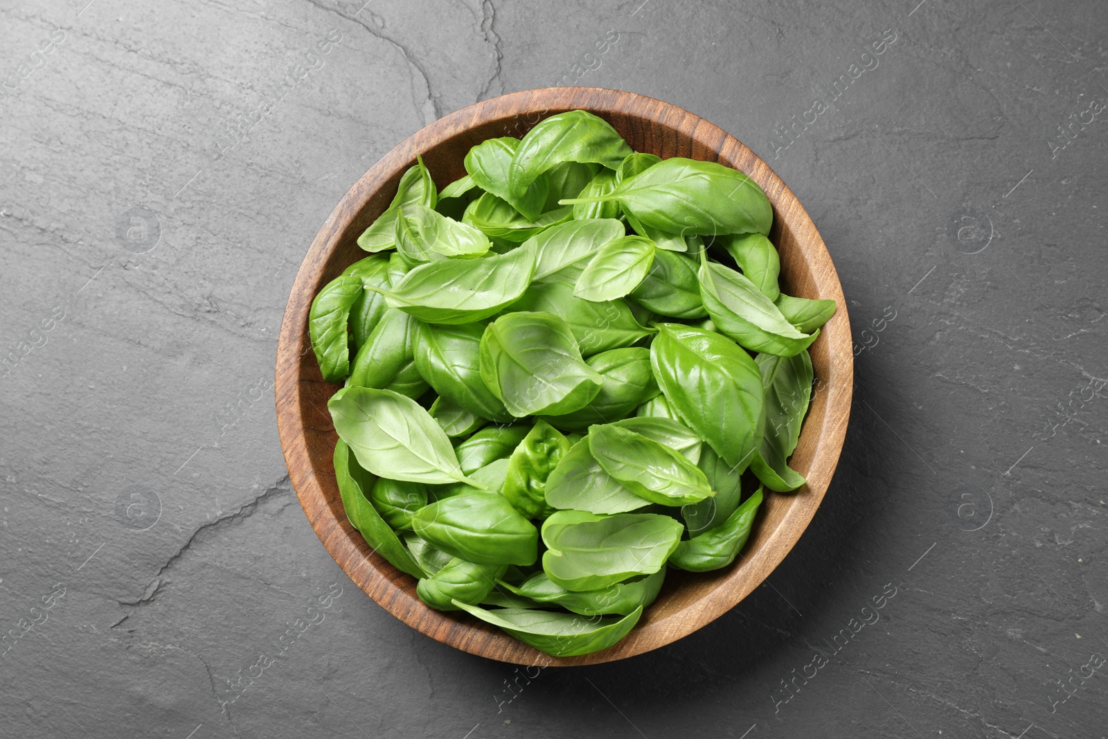 Fresh basil leaves on grey table, top view Photo of Fresh basil leaves on grey table, top view