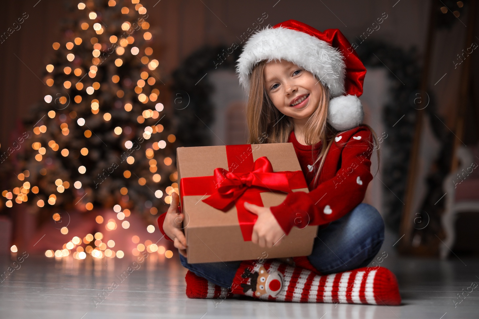 Cute little child with Christmas gift at home Photo of Cute little child with Christmas gift at home